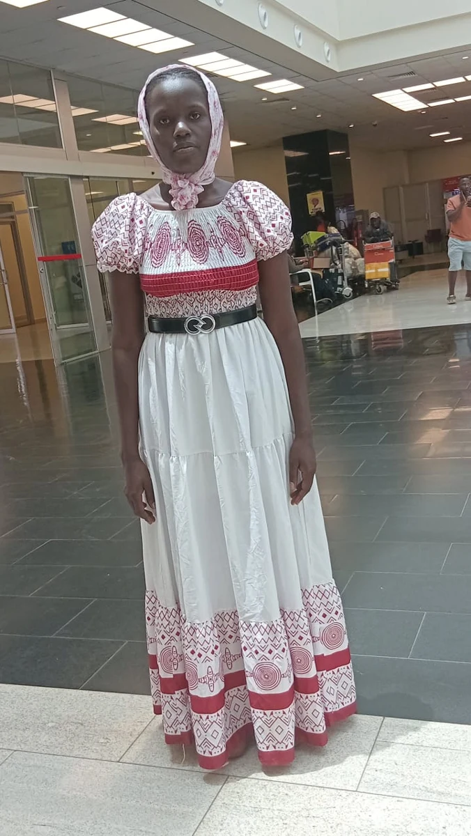 Traveler in a patterned dress in an airport terminal