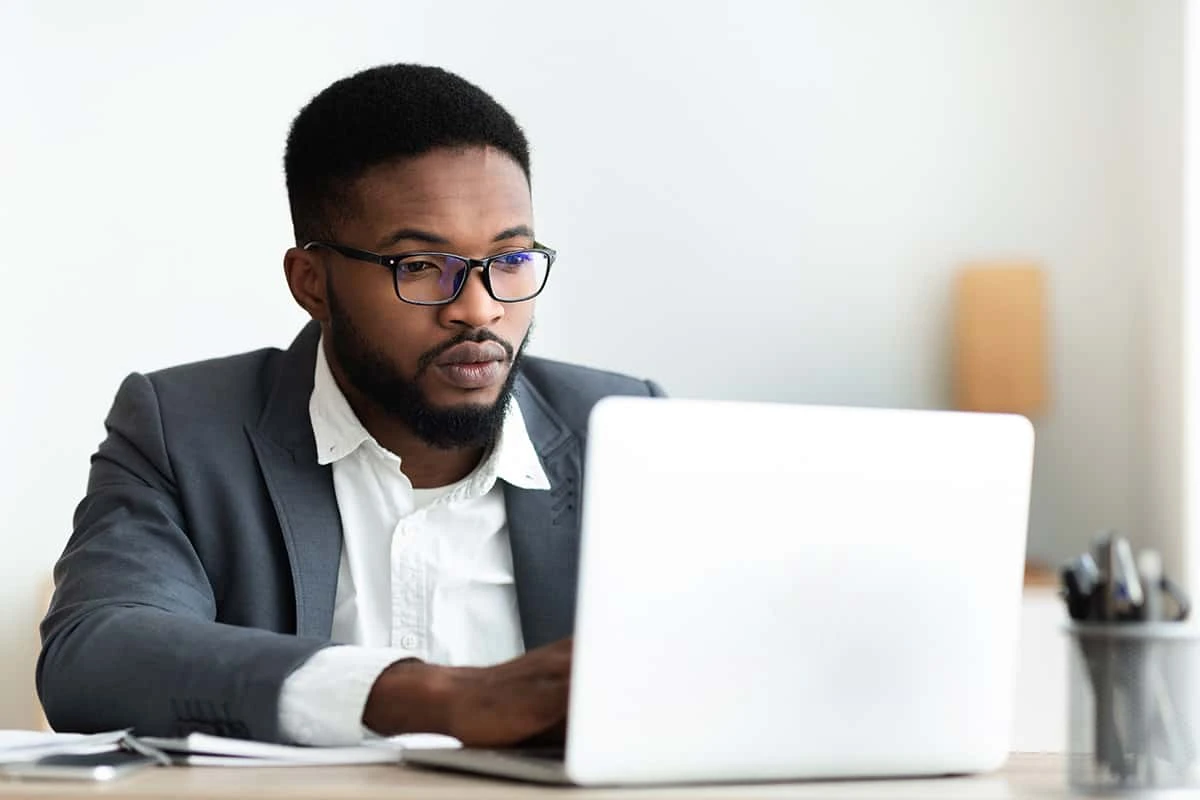 A professional reviewing work on a laptop